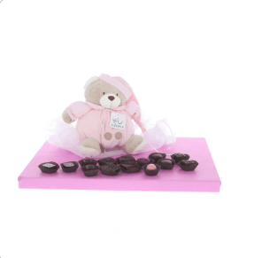 Plush baby toy with music playing pull-string surrounded by delicious Belgian pralines - Girl