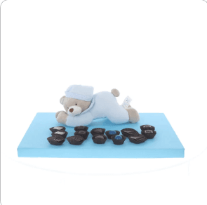 Blue lying teddy with display of Belgian chocolates