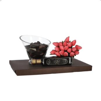 Stunning glass bowl filled with Belgian chocolates, bottle of chocolate liquor, and bouquet of fake tulips